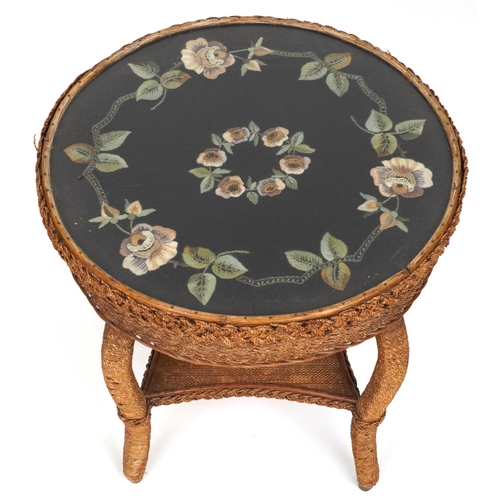 1014 - Cane and wicker occasional table with needlepoint upholstered top and under tier, 55cm high x 56cm i... 