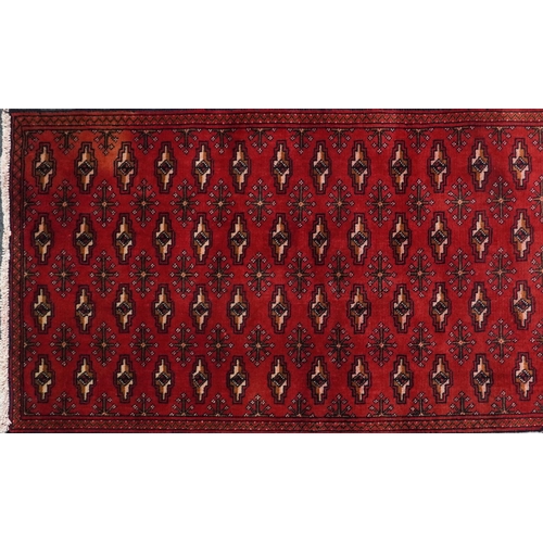 1031 - Rectangular carpet runner having an allover geometric design onto a red and blue ground, 330cm x 69c... 