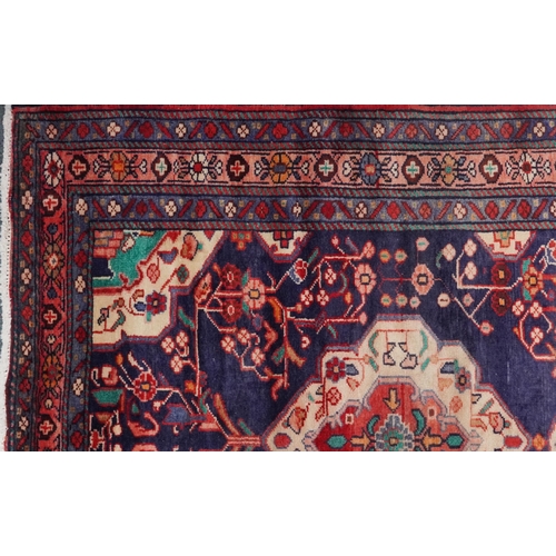 1030 - Rectangular Hamadan rug having an allover geometric floral design onto a predominantly red and blue ... 