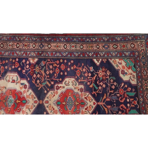 1030 - Rectangular Hamadan rug having an allover geometric floral design onto a predominantly red and blue ... 