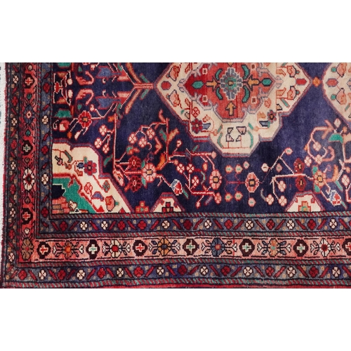 1030 - Rectangular Hamadan rug having an allover geometric floral design onto a predominantly red and blue ... 