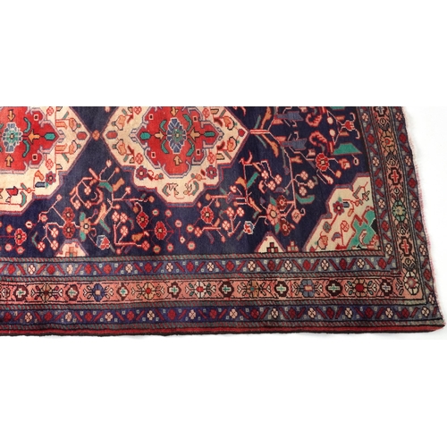 1030 - Rectangular Hamadan rug having an allover geometric floral design onto a predominantly red and blue ... 