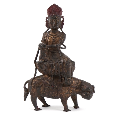 287 - Chinese partially gilt bronze figure of a Buddha riding a mythical beast, 32cm high