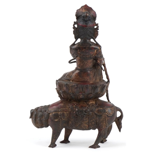 287 - Chinese partially gilt bronze figure of a Buddha riding a mythical beast, 32cm high