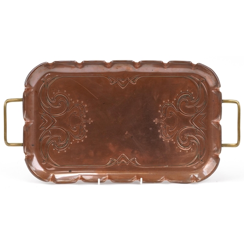 173 - Arts & Crafts copper and brass tray with stylized decoration mounted on small brass feet, impressed ... 