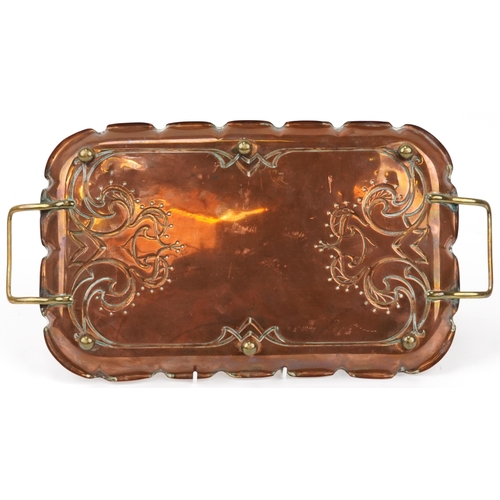 173 - Arts & Crafts copper and brass tray with stylized decoration mounted on small brass feet, impressed ... 