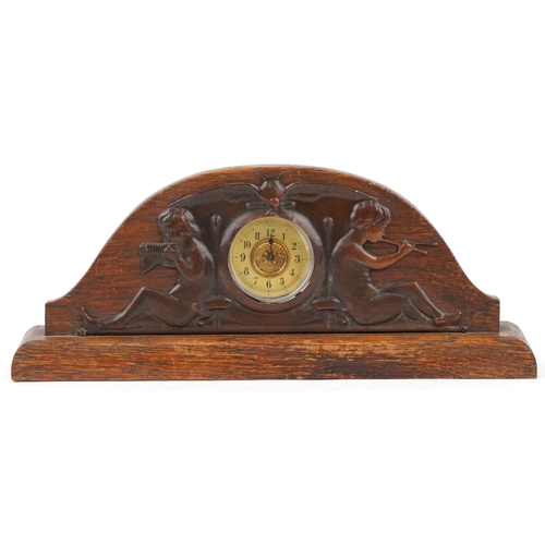 161 - Arts & Crafts oak and copper clock decorated with cherubs playing pan pipes, 32cm in diameter