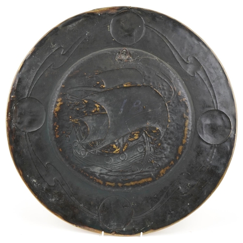 253 - Large Arts & Crafts brass charger decorated with a galleon in full sail, 52cm in diameter