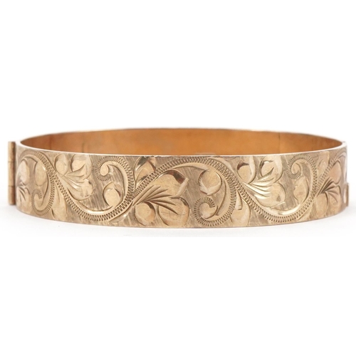 3096 - 9ct gold hinged bangle with floral engraved decoration, 6.5cm wide, 24.6g