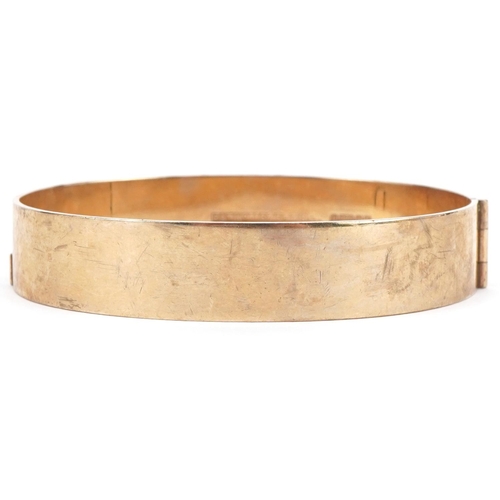 3096 - 9ct gold hinged bangle with floral engraved decoration, 6.5cm wide, 24.6g