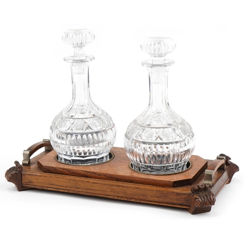 1164 - Victorian oak decanter stand with two good quality cut glass decanters, the stand 39cm in diameter