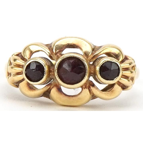 3232 - Continental 14ct gold bow design ring set with three garnets, size M, 2.2g