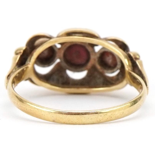 3232 - Continental 14ct gold bow design ring set with three garnets, size M, 2.2g