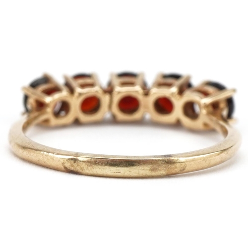 3196 - Unmarked gold garnet five stone ring, size R, 3.6g