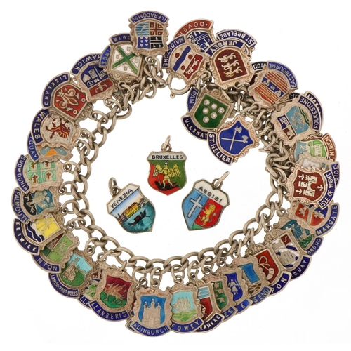 3435 - Silver charm bracelet with large collection of enamelled souvenir shield charms, 68.2g