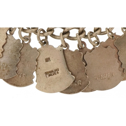 3435 - Silver charm bracelet with large collection of enamelled souvenir shield charms, 68.2g