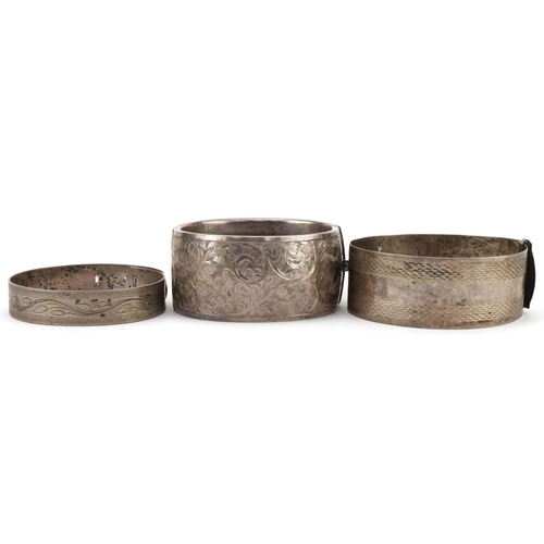 3444 - Three antique and later silver bangles, two with floral engraved decoration, total 96.8g