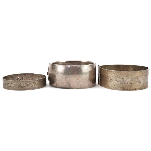 3444 - Three antique and later silver bangles, two with floral engraved decoration, total 96.8g