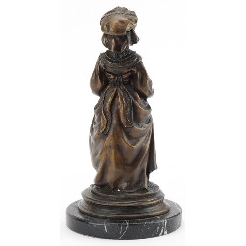 1003 - Bronze figure of a young Dutch female carrying fruit in a dress, raised on a black marble base, 26cm... 