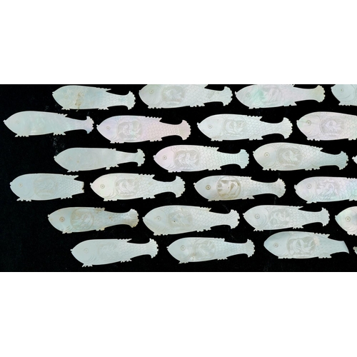 1213 - Eighty four mother of pearl fish counters, each 6cm in diameter