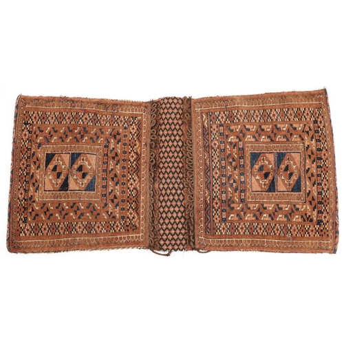 1338 - Rectangular Afghan brown ground saddle bag having an allover repeat design, 110cm x 56cm