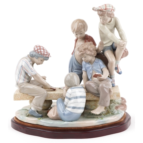 2098 - Large Nao porcelain figure group of boys playing cards, raised on a wooden plinth base, 34cm high x ... 