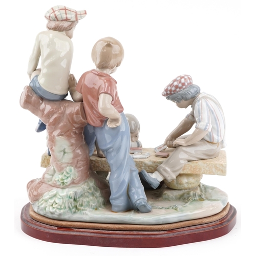 2098 - Large Nao porcelain figure group of boys playing cards, raised on a wooden plinth base, 34cm high x ... 