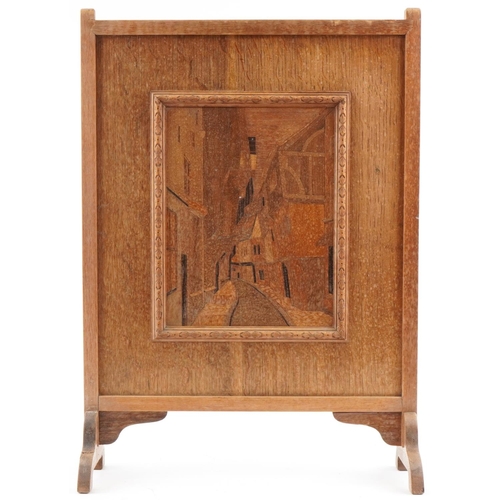 166 - Arts & Crafts oak marquetry panel fire screen with cobbled street scene, 67cm x 50cm