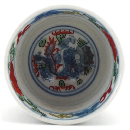 1202 - Miniature Chinese cup hand painted with objects and figures, character mark to the base, 4cm high