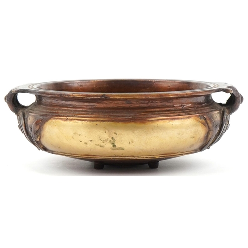 505 - Bronze Art Nouveau bowl with floral handles mounted on four tripod feet, 23cm in diameter