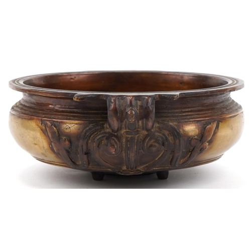 505 - Bronze Art Nouveau bowl with floral handles mounted on four tripod feet, 23cm in diameter