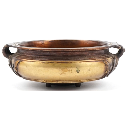 505 - Bronze Art Nouveau bowl with floral handles mounted on four tripod feet, 23cm in diameter