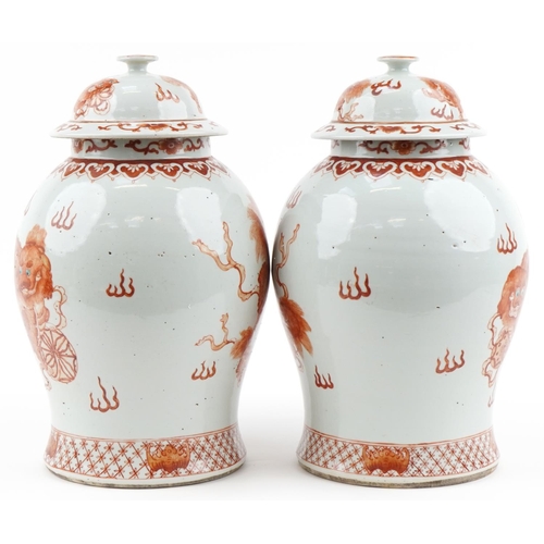 1104 - Large pair of Chinese porcelain baluster vases with covers, each hand painted in iron red with dogs ... 