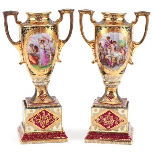 1250 - Pair of Vienna porcelain urns decorated with maidens and cherubs, marked to the base, 23cm high