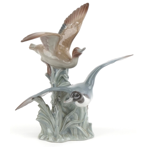 2099 - Lladro porcelain group of two ducks in flight, 31cm high