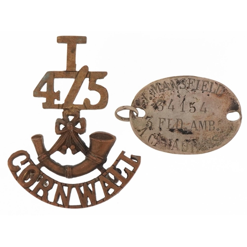 2538 - Military interest dog tag for J Mansfield 34154 3FLD.AMV and a brass Cornwall regiment badge, the la... 