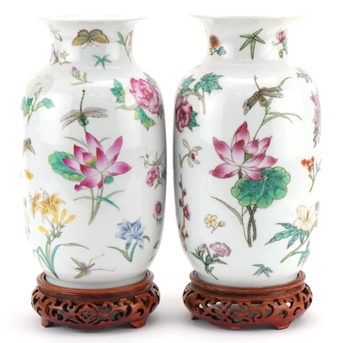 1016 - Pair of Chinese porcelain vases decorated with flowers and insects and mounted on wooden stands, eac... 