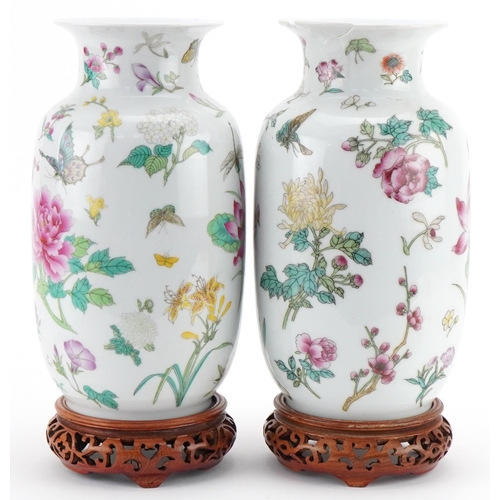 1016 - Pair of Chinese porcelain vases decorated with flowers and insects and mounted on wooden stands, eac... 