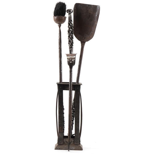 147 - Arts & Crafts wrought iron companion fire set and a wrought iron stand, the largest 56cm high