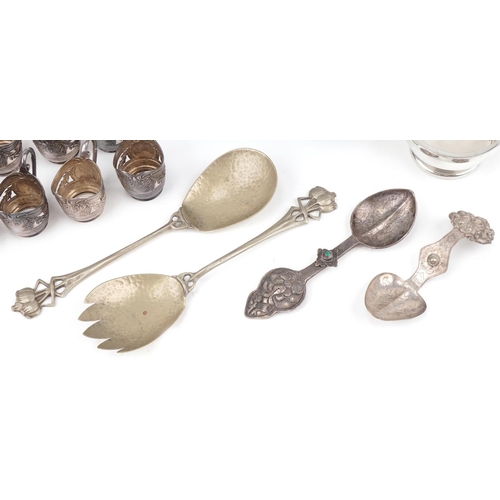 501 - Assorted Arts & Crafts metalware including spoons, liqueurs holders, quaich and silver plated fruit ... 