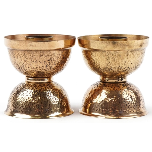 172 - Pair of Arts & Crafts brass candlesticks with hammered decoration,10cm high