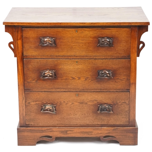 546 - George V Arts & Crafts oak chest of three long drawers with embossed copper handles, 84cm H x 91cm W... 