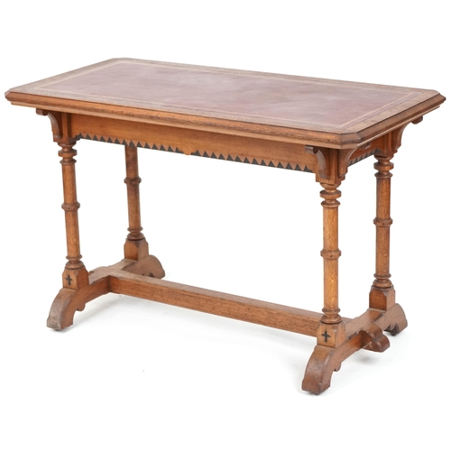 567 - Late Victorian Gothic Revival oak writing table, the top inset with a red gilt tooled leather writin... 