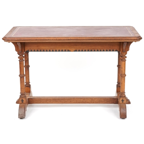 567 - Late Victorian Gothic Revival oak writing table, the top inset with a red gilt tooled leather writin... 