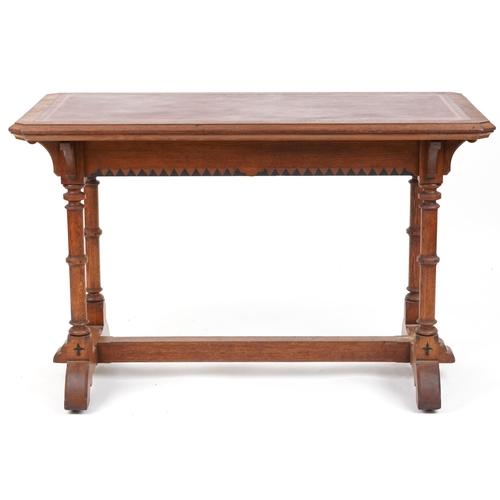 567 - Late Victorian Gothic Revival oak writing table, the top inset with a red gilt tooled leather writin... 