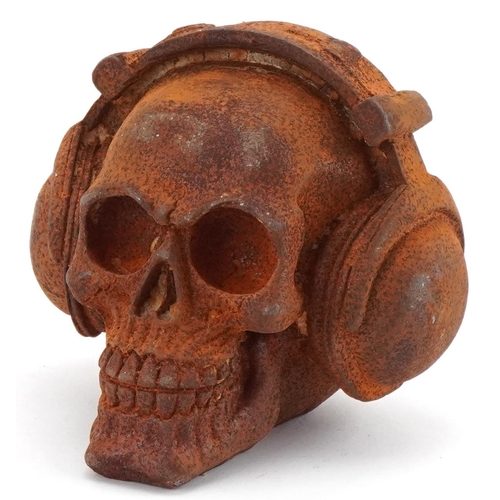 2178 - Cast iron study of a human skeleton with headphones, 13cm high