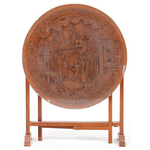 738 - Chinese hardwood folding occasional table, 20th century, carved with figures amongst pagodas, 52cm h... 