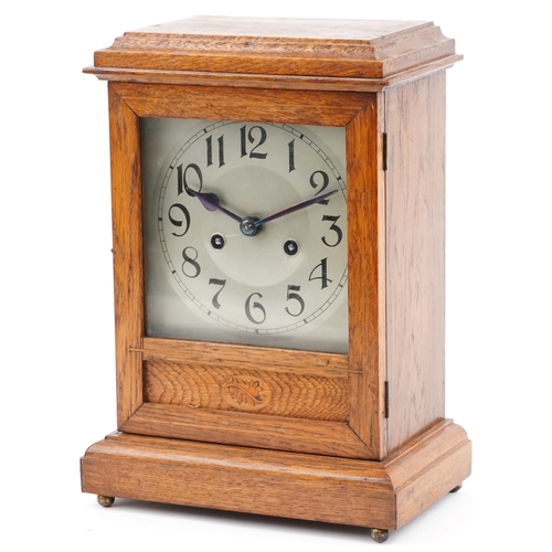 1197 - Oak cased mantle clock having silvered dial with Arabic numerals, striking on a gong, 34.5cm high