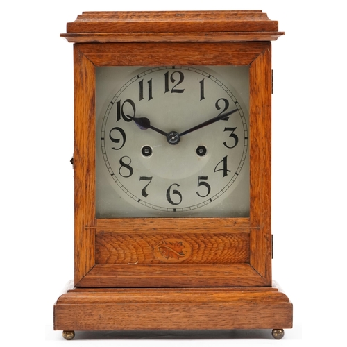 1197 - Oak cased mantle clock having silvered dial with Arabic numerals, striking on a gong, 34.5cm high