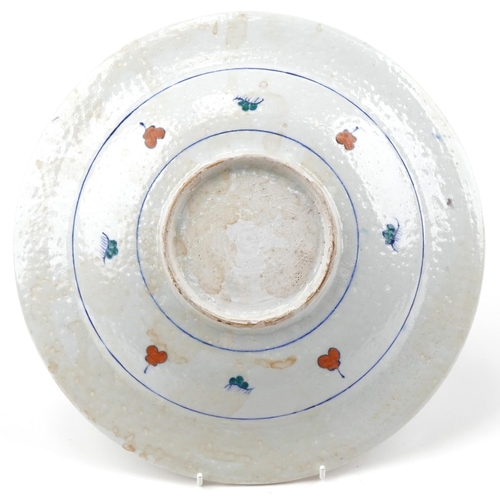 1283 - Turkish Ottoman Iznik plate hand painted with a figure and stylized flowers, 32cm in diameter